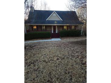 Charming single-Gathering home featuring a cozy porch and well-maintained front yard landscaping at 95 Jenna Ln, Covington, GA 30016