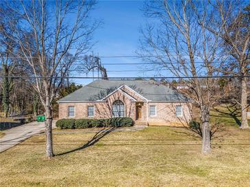 Brick ranch house with a landscaped lawn and mature trees at 3542 Linecrest Rd, Ellenwood, GA 30294