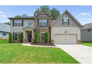 Two-story house with brick and siding, landscaped lawn, and driveway at 6235 Stillwood Ln, Cumming, GA 30041