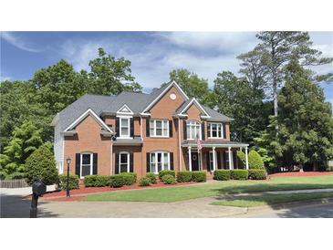 Two-story brick home with a large front yard and mature trees at 2968 Winterthur Close Nw, Kennesaw, GA 30144