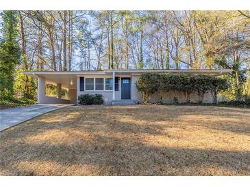 Ranch style home with gray brick exterior, attached carport, and landscaped lawn at 3701 Glen Mora Dr, Decatur, GA 30032
