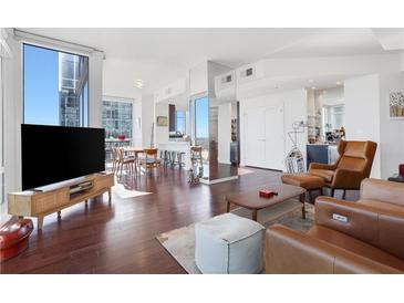 Bright, open-concept living space with hardwood floors, modern furniture, and floor-to-ceiling windows offering city views at 3325 Piedmont Ne Rd # 2702, Atlanta, GA 30305