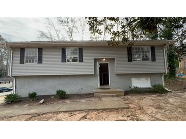 Ranch style home with gray siding, brick skirt, and a partially visible driveway at 1272 Marlwood Ct, Stone Mountain, GA 30083