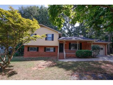 Brick ranch house with attached garage and landscaped yard at 500 Carillon Ct, Stone Mountain, GA 30083