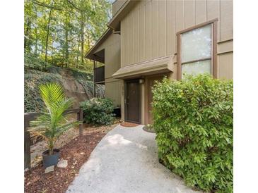 Inviting condo entrance with a walkway, landscaping, and wooded backdrop at 2707 Cumberland Se Ct, Smyrna, GA 30080