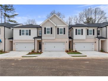 Two story townhome with attached garage and modern exterior finishes at 401 Brooch Way, Stockbridge, GA 30281