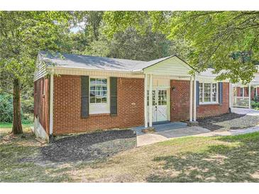 Brick ranch house with a covered porch and well-maintained lawn at 895 Kings Grant Nw Dr, Atlanta, GA 30318