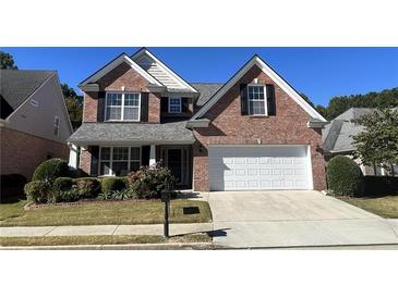 Brick two-story house with a white garage door and landscaping at 2280 Hickory Station Cir, Snellville, GA 30078