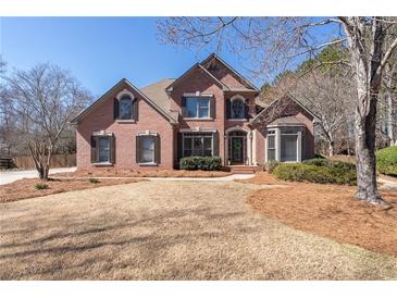 Charming brick two-story home with manicured lawn and mature landscaping at 909 Waterton Ct, Suwanee, GA 30024