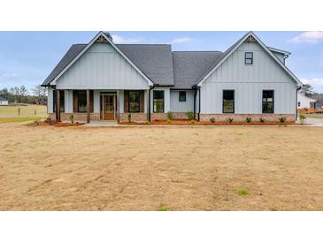 Two-story farmhouse with gray siding, covered porch, and brick accents at 628 Ridge Rd, Dallas, GA 30157