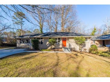 Ranch style home with brick facade, red door, and a well-manicured lawn at 2599 Browns Mill Se Rd, Atlanta, GA 30354