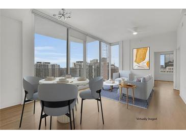 Bright living room with city views, hardwood floors, and modern furniture at 860 Peachtree Ne St # 1617, Atlanta, GA 30308