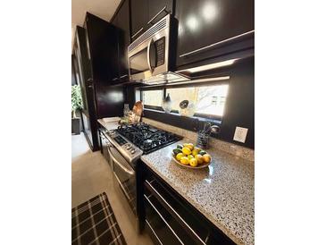 Modern kitchen featuring stainless steel appliances, granite countertops, and sleek, dark cabinetry at 972 Dekalb Ne Ave # 203, Atlanta, GA 30307