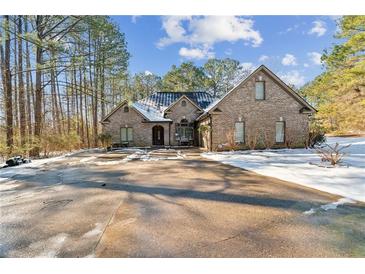 Brick home with a large driveway, partially covered in snow at 570 Pleasant Grove Rd, Mcdonough, GA 30252