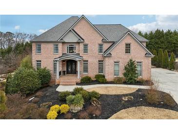 Two-story brick home with landscaped yard and large driveway at 206 Woodridge Pkwy, Canton, GA 30115