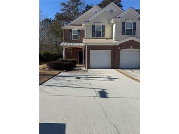 Two-story brick and vinyl townhome with a two-car garage and well-manicured lawn at 101 Ellis Dr # 101, Conyers, GA 30012