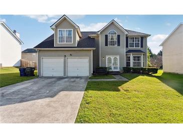 Two-story house with a two-car garage and a well-maintained lawn at 4450 Millenium View Ct, Snellville, GA 30039