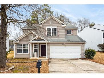Two-story house with beige siding, a two-car garage, and a small front yard at 5480 Sable Bay Pt, Atlanta, GA 30349