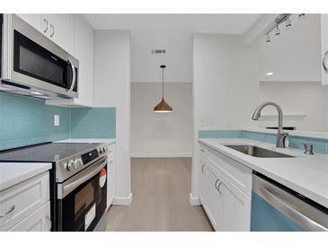 Modern kitchen with stainless steel appliances and light blue tile backsplash at 1412 Tuxworth Cir, Decatur, GA 30033