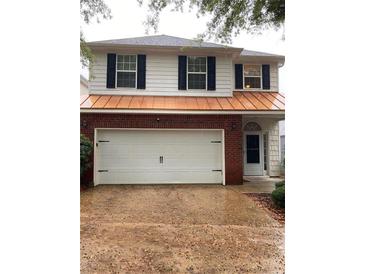 Two-story house with white siding, brick base, and copper roof at 403 Buckboard Ln, Locust Grove, GA 30248