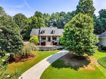 Inviting home with a long driveway, manicured lawn, and lush landscaping at 1004 Fairway Seven, Villa Rica, GA 30180
