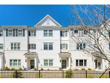 White three-story townhouses with black windows and a black fence at 1756 Evenstad Way, Smyrna, GA 30080