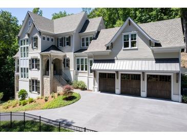 Two-story house with a three-car garage and manicured landscaping at 3244 Stillhouse Rd, Atlanta, GA 30339