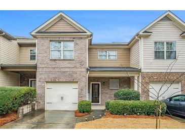 Charming townhome with brick and siding exterior, attached garage, and well-maintained landscaping at 1328 Stone Bay Sw Dr, South Fulton, GA 30331