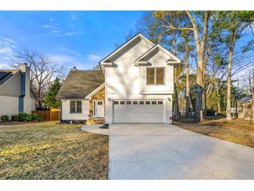 Newly renovated two-story home with a large driveway and landscaped lawn at 2473 Baker Rd, Atlanta, GA 30318