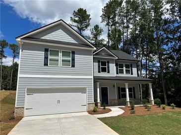 Two-story house with gray siding, a white garage door, and a landscaped yard at 5342 Legacy Trl, Douglasville, GA 30135