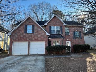 Brick house with two-car garage and manicured landscaping at 916 Brisley Cir, Hampton, GA 30228