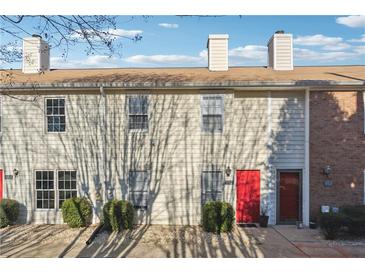 Beige townhome with red front door, landscaping, and tree shadows at 992 Old Holcomb Bridge Rd, Roswell, GA 30076