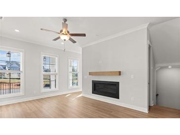 Bright living room features hardwood floors, fireplace, and large windows at 124 Stonehouse Dr, Cumming, GA 30040