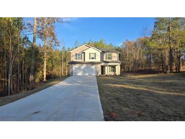 Two-story house with gray siding, attached garage, and a long driveway at 100 Heyman Dr, Covington, GA 30016