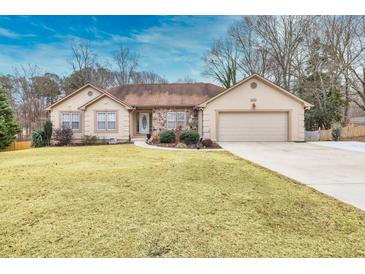 Ranch style home with attached garage and landscaped lawn at 2129 Lakeland Ct, Dacula, GA 30019