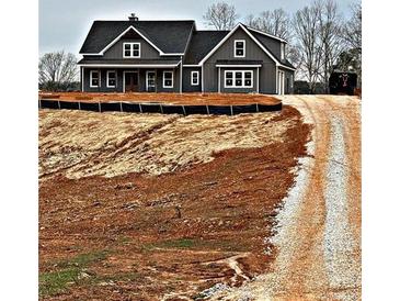 Gray farmhouse exterior with gravel driveway and unfinished landscaping at 1330 Temple Draketown Rd, Temple, GA 30179