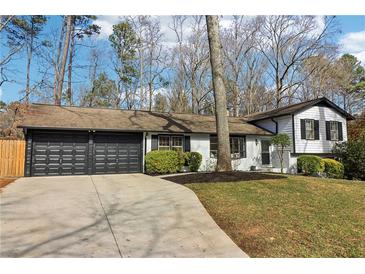 Ranch home with attached garage, landscaped lawn, and a driveway at 2667 Flair Knoll Ne Dr, Atlanta, GA 30345