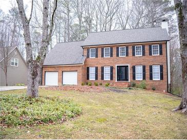 Two-story brick house with attached two-car garage and landscaped lawn at 1853 Edington Sw Rd, Marietta, GA 30064