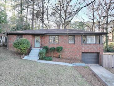 Brick ranch house with attached garage and landscaped yard at 2107 Seavey Dr, Decatur, GA 30032