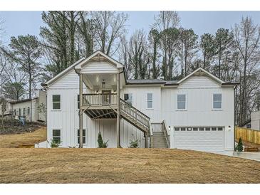Charming two-story home with board and batten siding, a covered porch, and an attached garage at 4322 Timberland Sw Dr, Lilburn, GA 30047