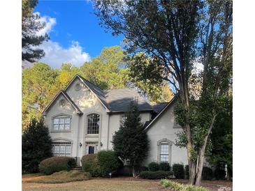 Two-story house with stucco siding, landscaping, and a tree-lined yard at 2080 Milfield Cir, Snellville, GA 30078