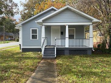 Charming gray house with a front porch and well-manicured lawn at 967 Metropolitan Sw Pkwy, Atlanta, GA 30310