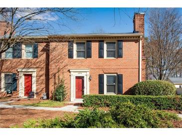 Charming brick townhouse with red door, black shutters, and well-manicured landscaping at 1094 Old Roswell Rd, Roswell, GA 30076