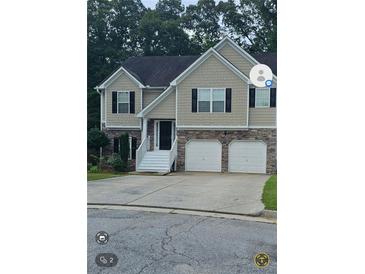 Two-story house with stone and siding, a two-car garage, and a landscaped yard at 4115 Brightmore Dr, Austell, GA 30106