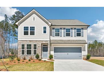 Charming two-story home with stone accents, manicured lawn, and a spacious two-car garage at 7293 Eton Ln, Locust Grove, GA 30248
