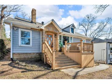 Charming gray house with stone accents, a deck, and steps leading to the entrance at 727 Charlotte Nw Pl, Atlanta, GA 30318