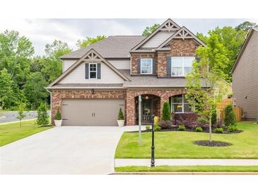 Beautiful two-story brick home with a well-manicured lawn and two car garage in a lovely neighborhood at 2090 Red Barn Ct, Cumming, GA 30040
