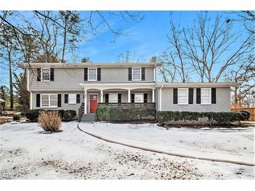 Two-story house with gray siding, red door, and a snow-covered yard at 4071 Williamsburg Dr, Atlanta, GA 30337
