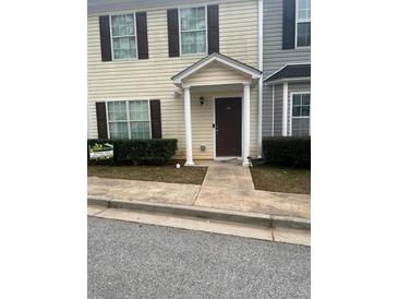 Tan two-story townhouse with brown shutters and a brown door at 990 Harbins Rd # 5D, Norcross, GA 30093