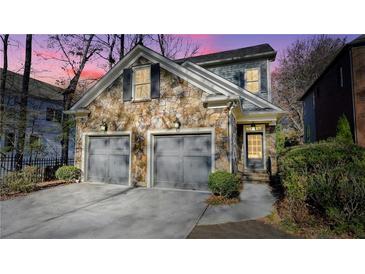 Stunning stone front exterior boasts a two-car garage and manicured landscaping at 1048 Standard Ne Dr, Atlanta, GA 30319